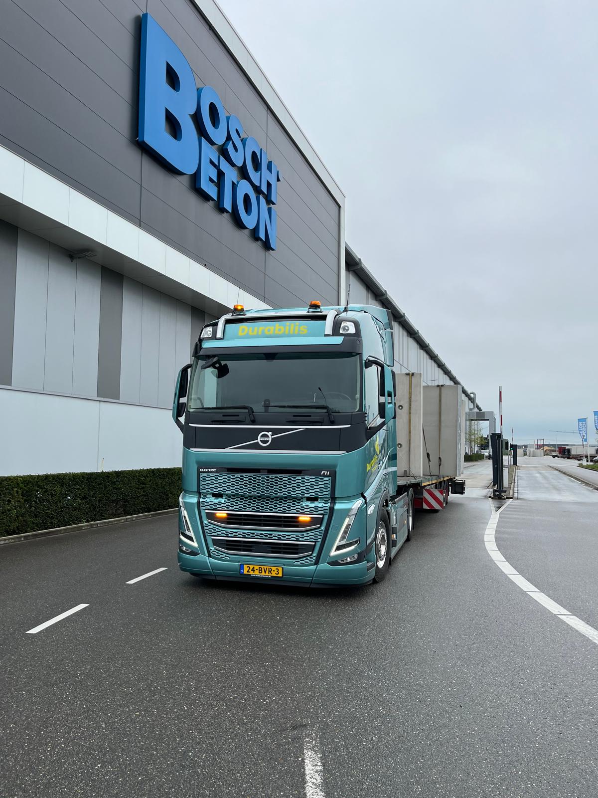 Elektrische vrachtwagen onderweg met bouwmateriaal